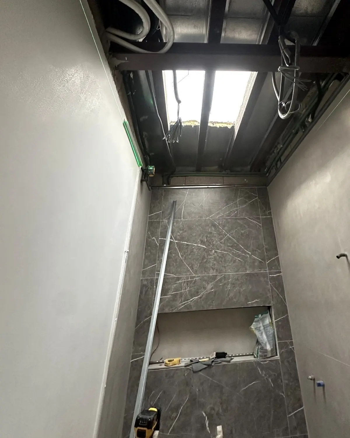 Baño en obra con la estructura del techo abierta alrededor del lucernario