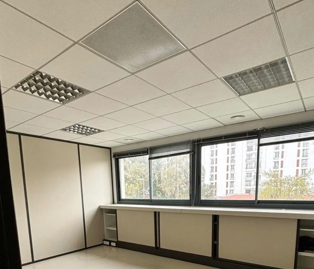 Despacho terminado con techo registrable modular, rejillas de climatización y luminarias integradas en la retícula del techo